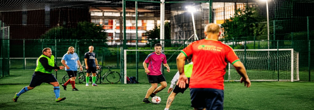 Players competing in a night pickup game on turf